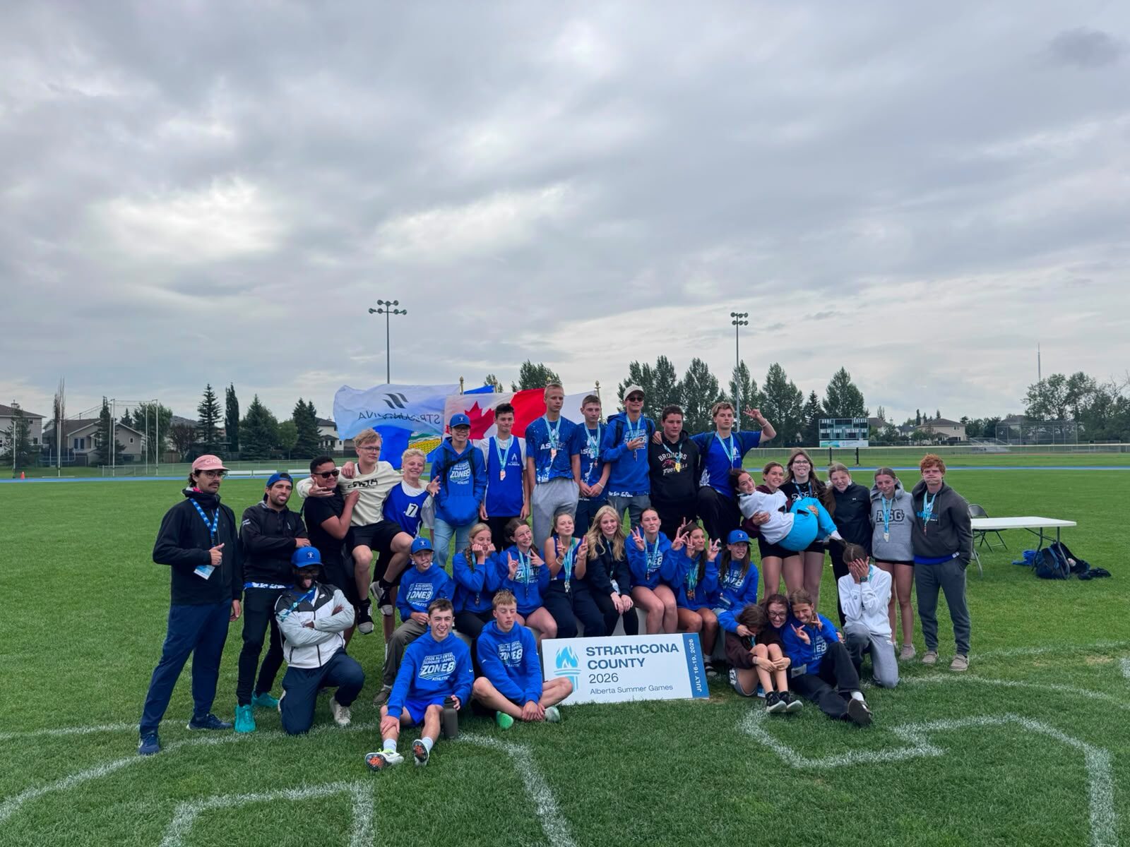 The Zone 8 team gathered on the field with flags raised