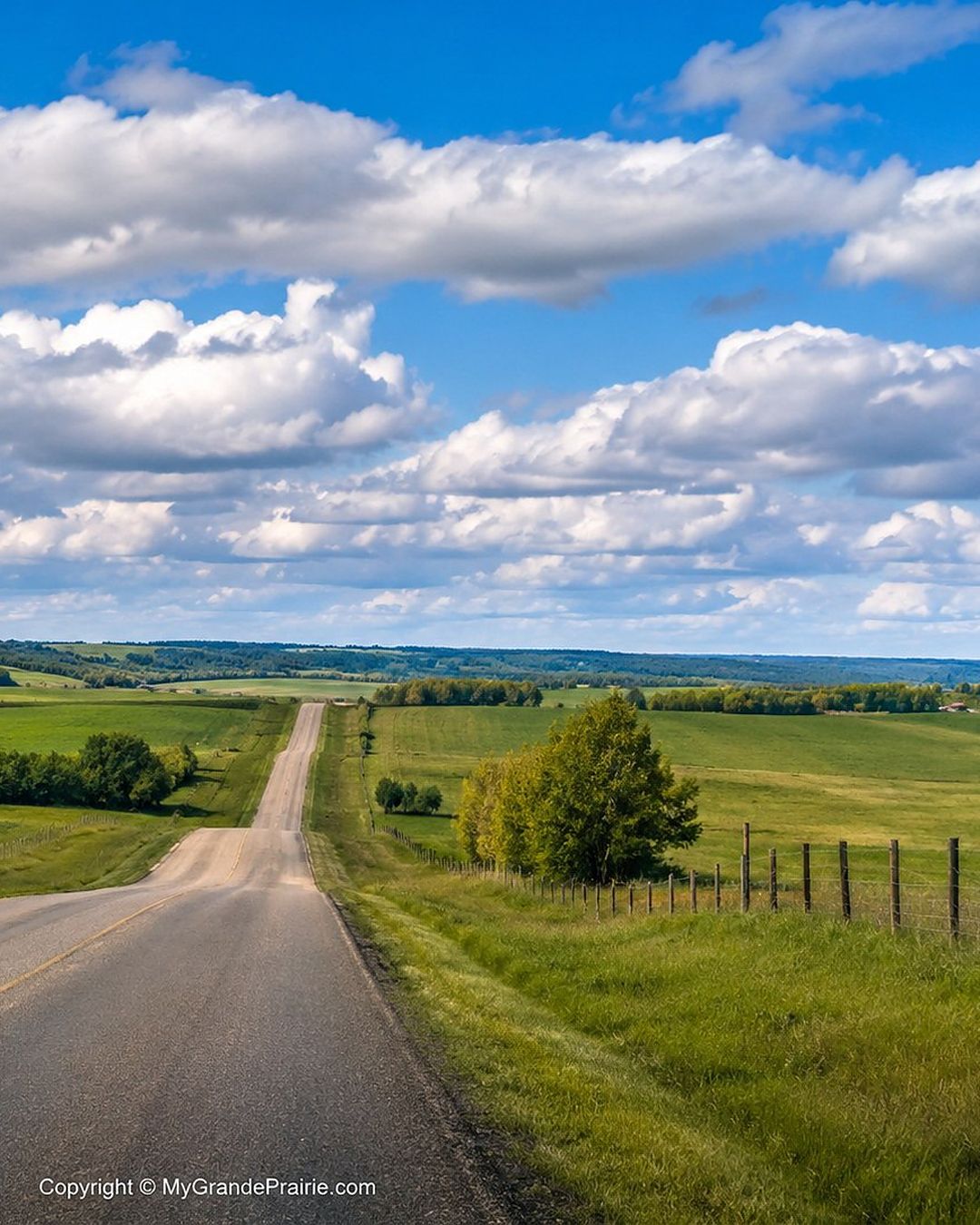 An acreage home set back from a country road at the edge of the prairie