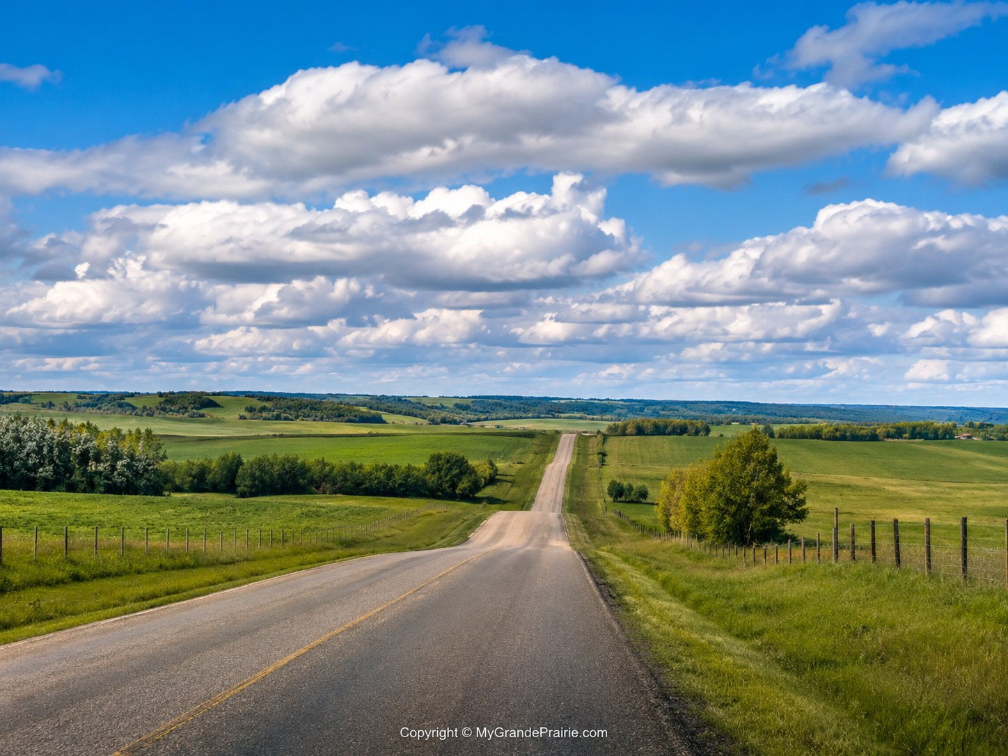 An acreage home on a country road at the edge of the prairie